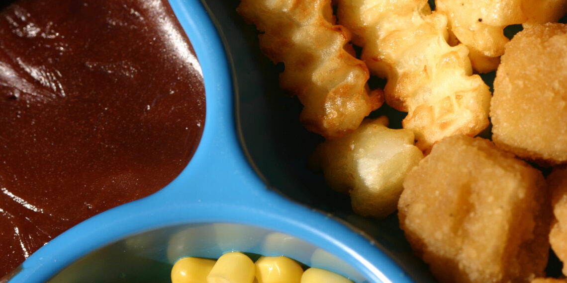 A close-up shot of food on a TV dinner plate.