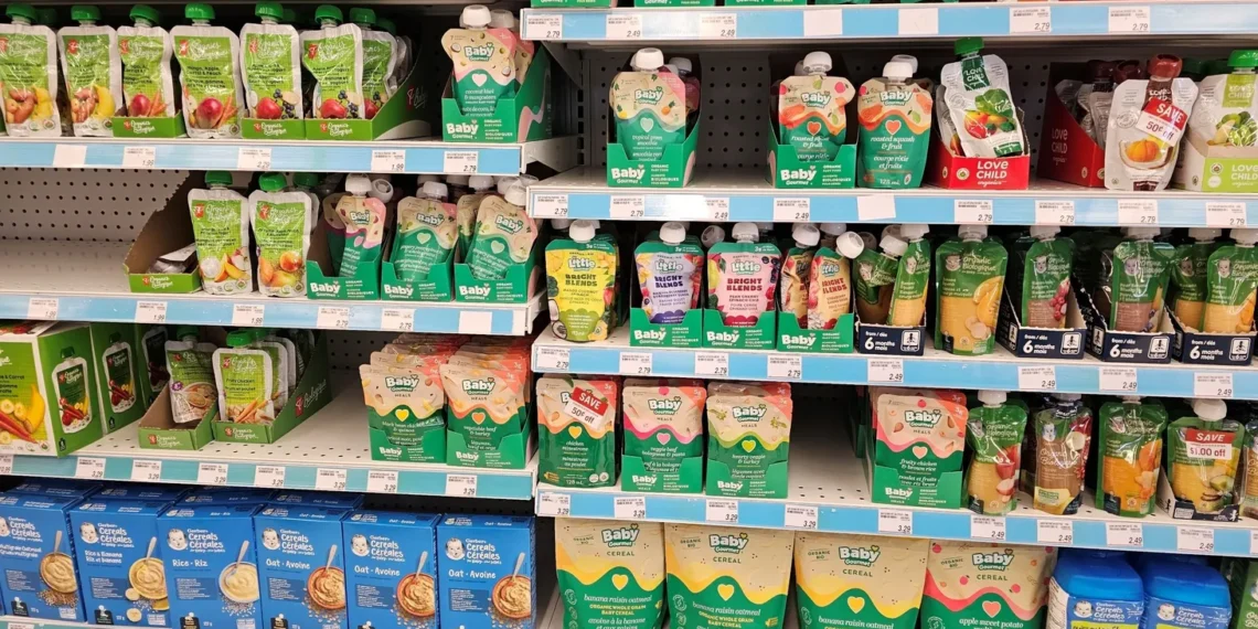 The baby food aisle of the grocery store is stocked with applesauce pouches.