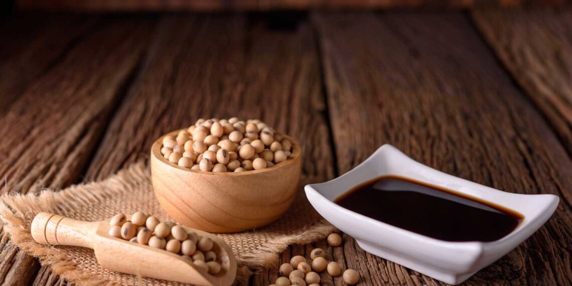 Soy sauce with soy bean on wooden background