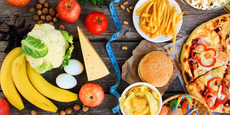 fruit and veggies on the left and fries, pizza and other junk food on the right, with a tape measure dividing them
