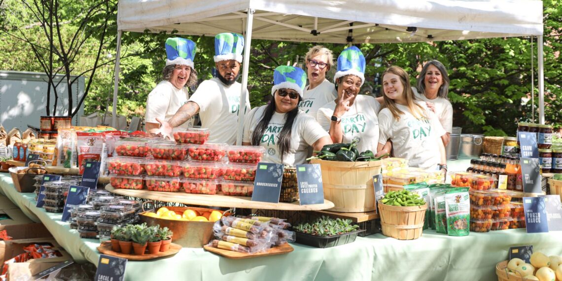 Seven workers at the Rand Farmers Market surrounded by produce