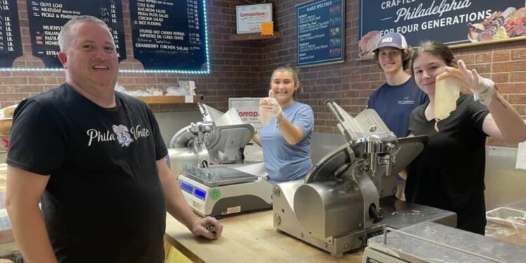 Charlie Frederick, left, of Darby Township, a customer for over 40 years, talks to Guy’s staff members, from left, Samantha Fail of Secane, Damian Penater of Springfield and Cailin Bauer-Smith of Glenolden, as they slice his cold cuts and fill his order