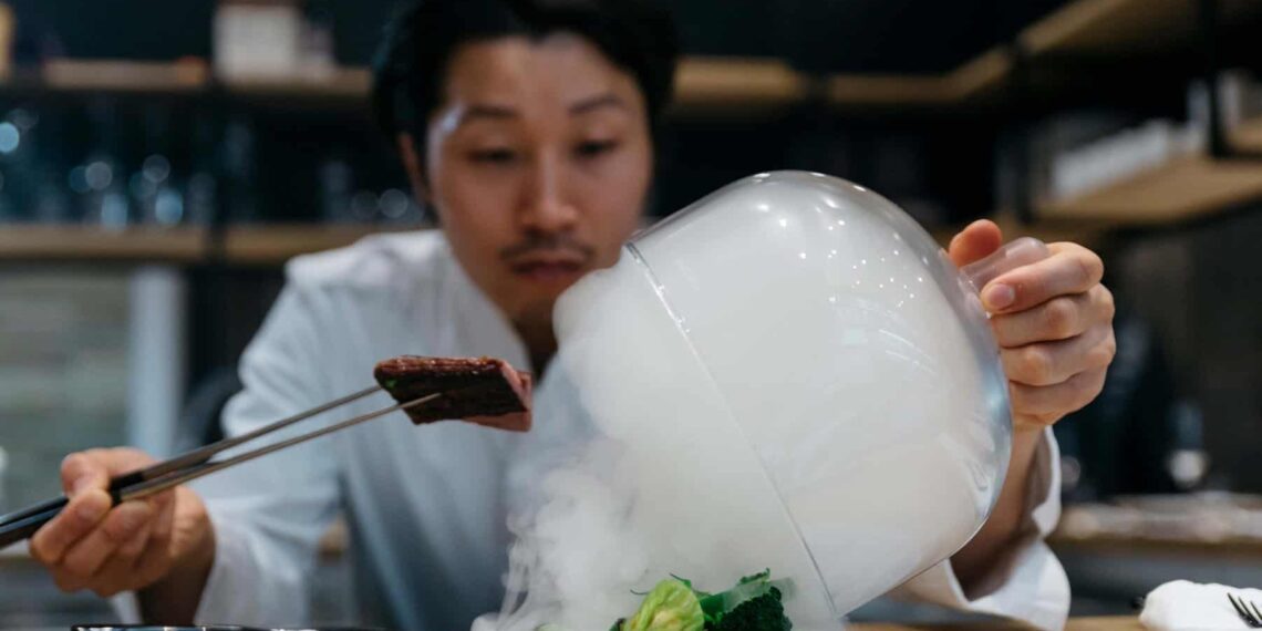 Chef cooking in restaurant with smoke dish; Shutterstock ID 1876615660