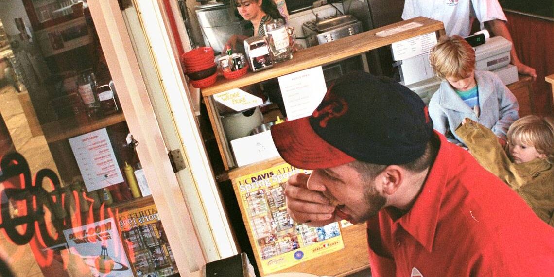 Regular customer Liam Riley eats his hot dog at the small counter in The Hotdogger, 129 E. Street, Davis.