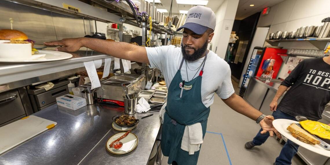 Chef Chayil Johnson of Community Matters Cafe expedites the line during a lunch rush.