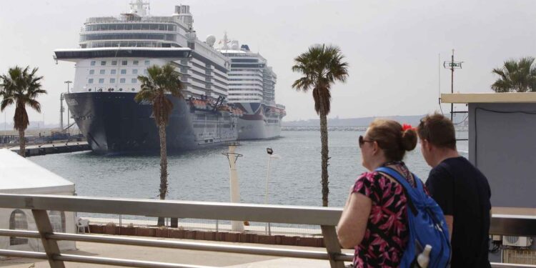 Dos turistas frente a un crucero, en una imagen de archivo.