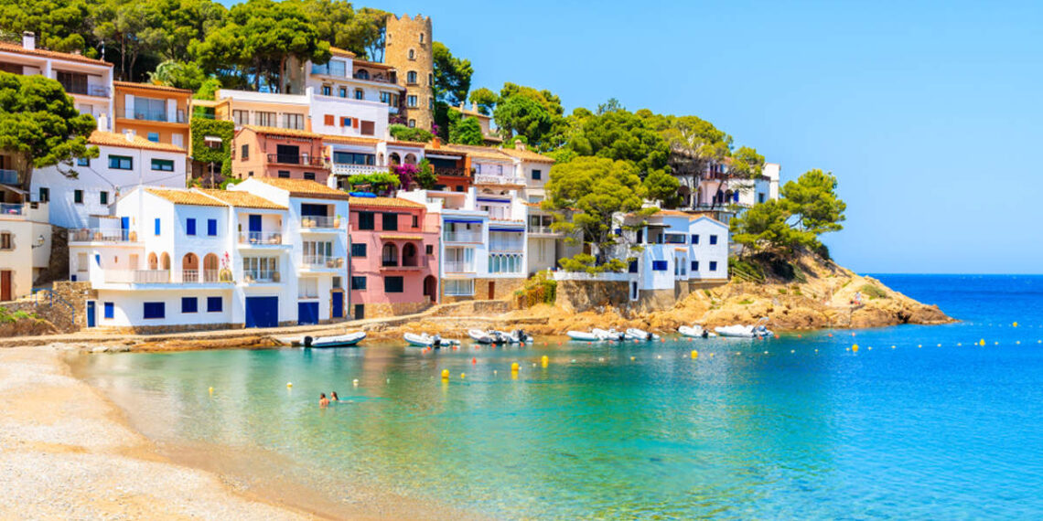 La playa de la Costa Brava con un anfiteatro de casitas marineras y aguas turquesas