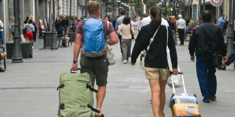 Turistas con maletas por Triana.