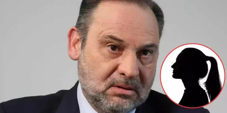 Hombre con barba y traje oscuro mirando al frente con una silueta de perfil de una mujer en un círculo rojo en la esquina inferior derecha.