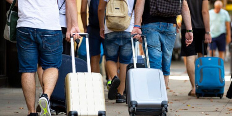 Un grupo de personas viajando con maletas y mochilas