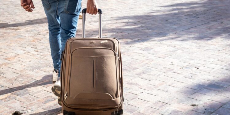 Un turista llevando una maleta.