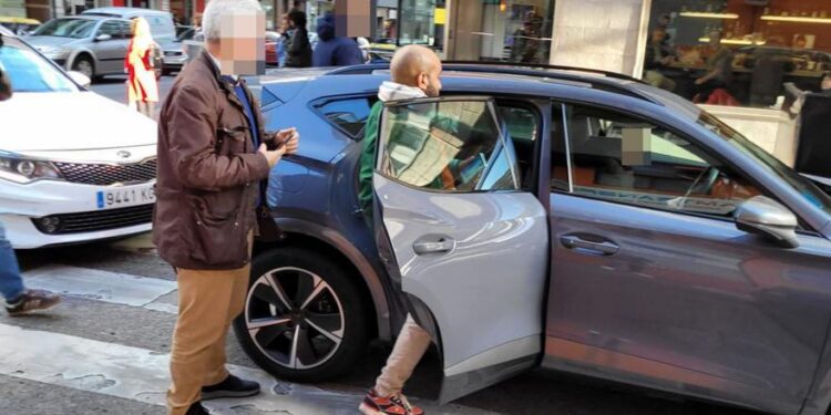 El propietario de la agencia de viajes, este martes, entra en el coche policial.