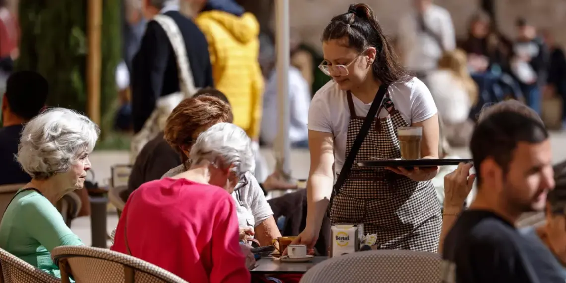 Una joven camarera sirve una mesa / EFE