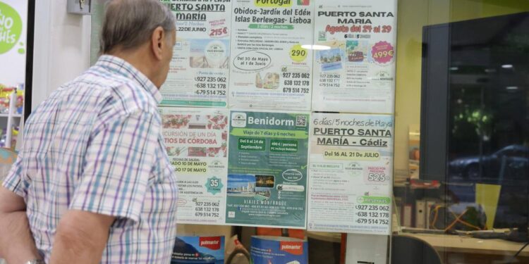 Un hombre mira ofertas de viajes en un escaparate.