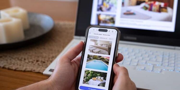 Unrecognizable person reviewing hotels online, using smartphone