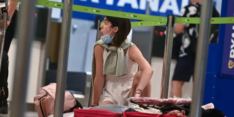 Una mujer prepara su maleta en el puesto de facturación de Ryanair / EFE