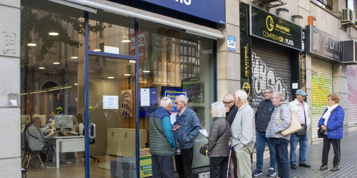 Pensionistas haciendo cola ayer a primera hora de la mañana en una agencia de la avenida Catalunya de Lleida.