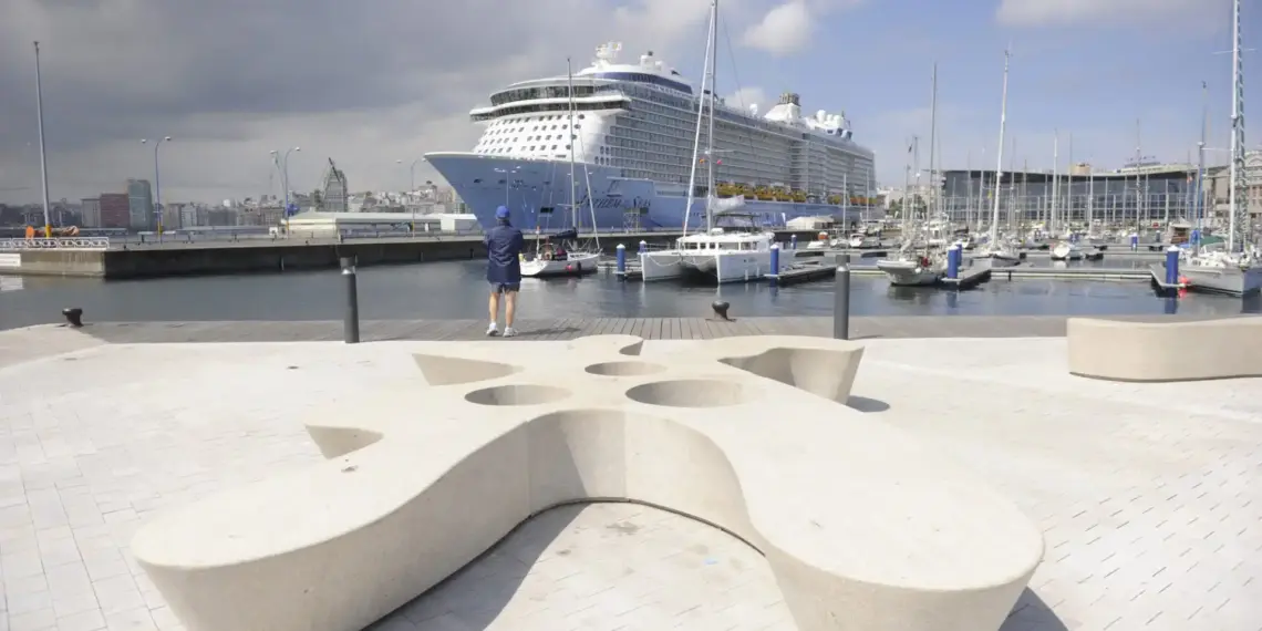 Gran crucero atracado junto al puerto deportivo de A Coruña con veleros y zona peatonal en primer plano