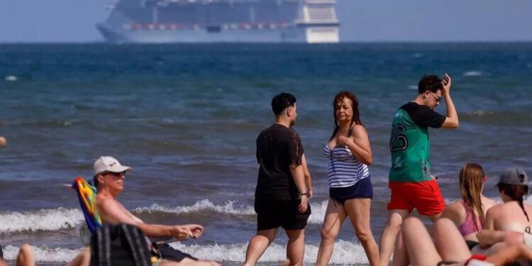 Bañistas y, al fondo, un crucero frente a la playa de la Malva-rosa