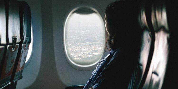 Una mujer mira por la ventanilla durante un vuelo.