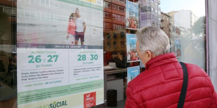 Un jubilado ojea los viajes del Imserso en un escaparate de una agencia de viajes gallega.