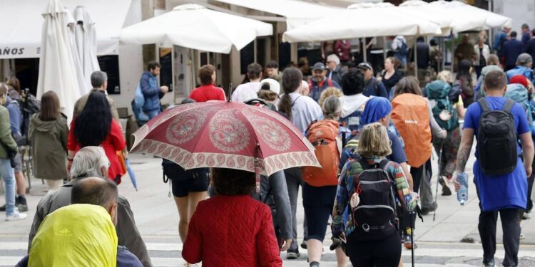 Compostelanos y turistas cruzan el paso de peatones de Porta Faxeira, que conecta la Alameda con el casco histórico.