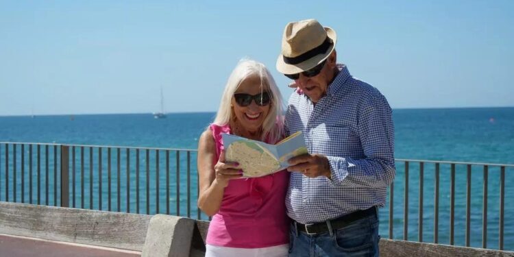 Una pareja de jubilados mirando un mapa durante su viaje del Imserso