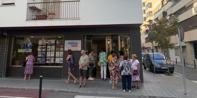 Pensionistas jubiladas, esperando en la puerta de la agencia de viajes esta mañana.