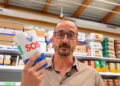 Un hombre en el supermercado con el paquete de SOS nuevo en la mano