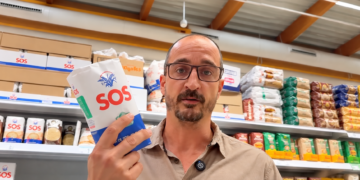 Un hombre en el supermercado con el paquete de SOS nuevo en la mano