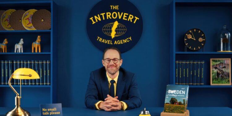 El chico de la agencia de viajes sentado en su escritorio